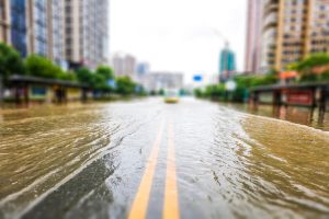 Floodwater flows down a city street 