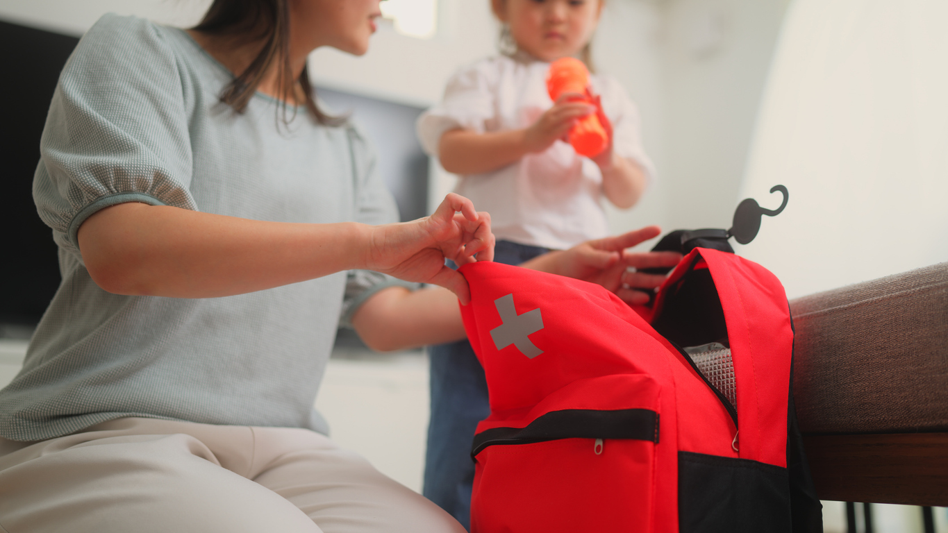 Parent and young child preparing emergency first aid bag