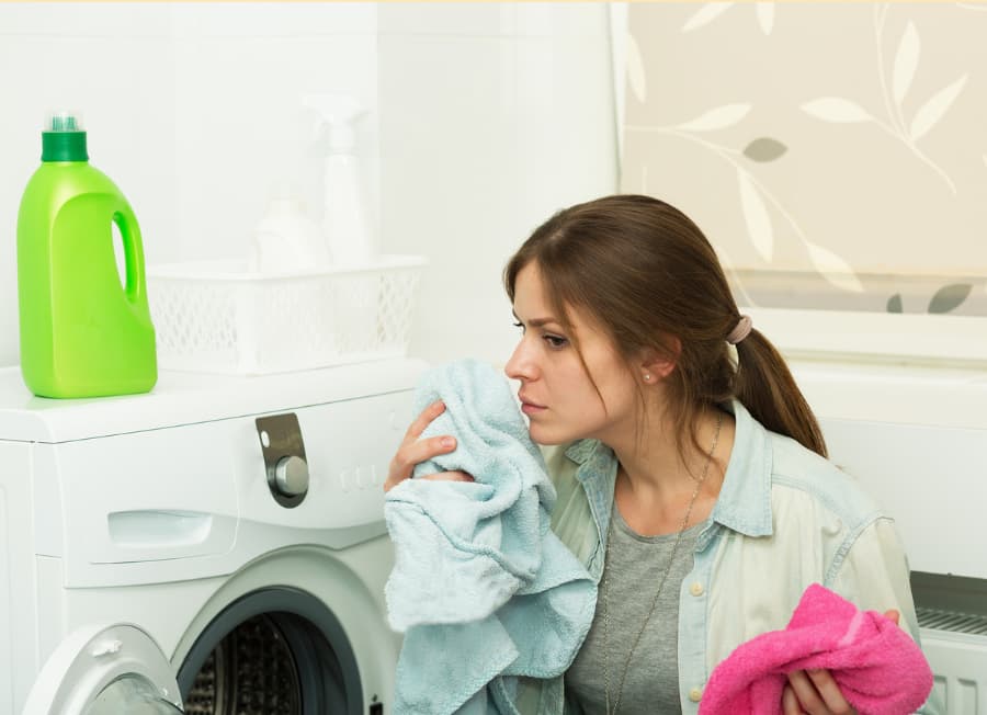 Person smelling laundry out of home dryer