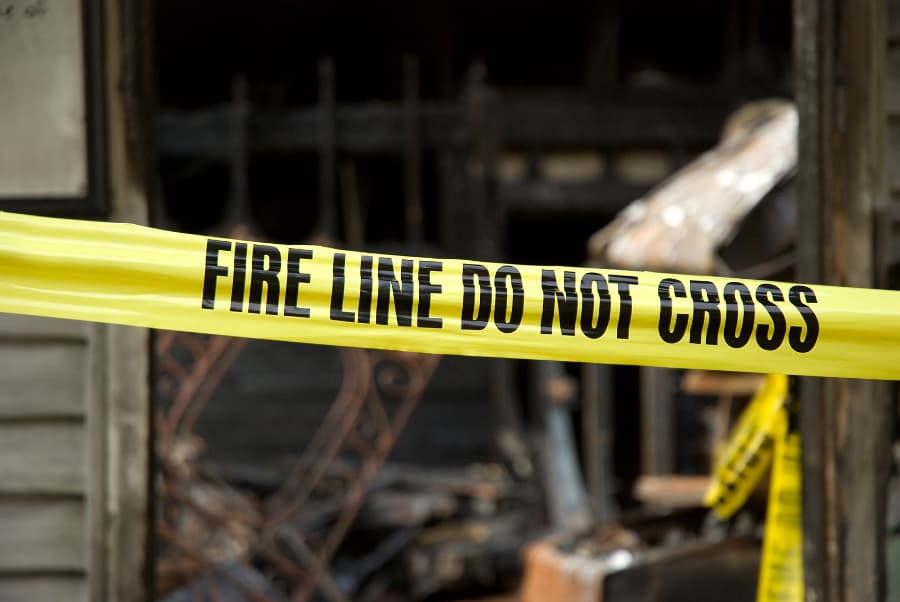 Caution tape in front of building damaged by fire