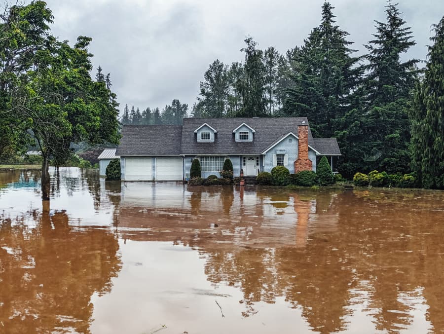 Exterior of home in residential neighborhood surrounded by extreme flooding